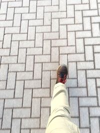 Low section of man walking on cobblestone