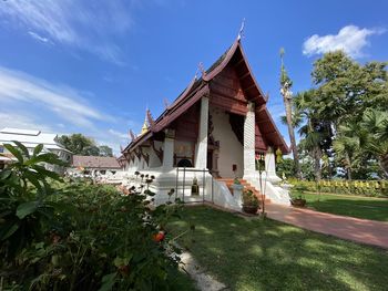 Traditional building by trees against sky