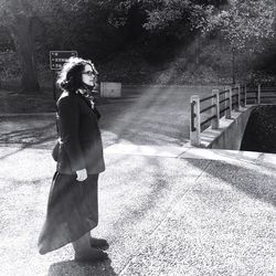 Full length of woman standing against trees