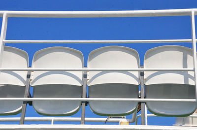 Low angle view of bleachers against clear blue sky