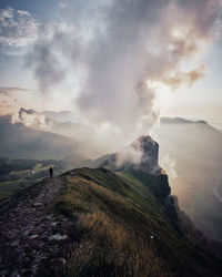 Scenic view of mountains against cloudy sky during sunset