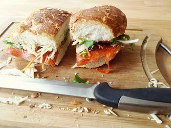 Close-up of pepperoni sandwich with knife on cutting board