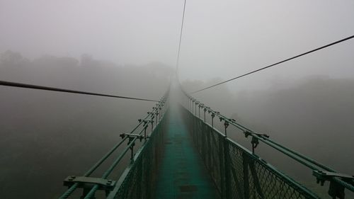 Suspension footbridge in foggy weather