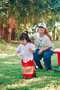 Side view of woman sitting on field