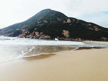 Scenic view of sea and mountains against sky