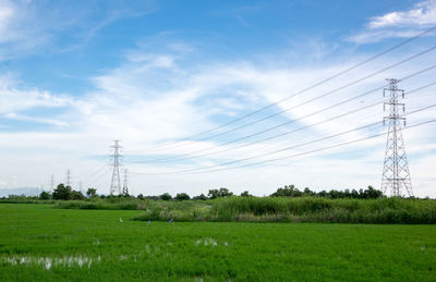 Electricity pylon against blue sky with cloud