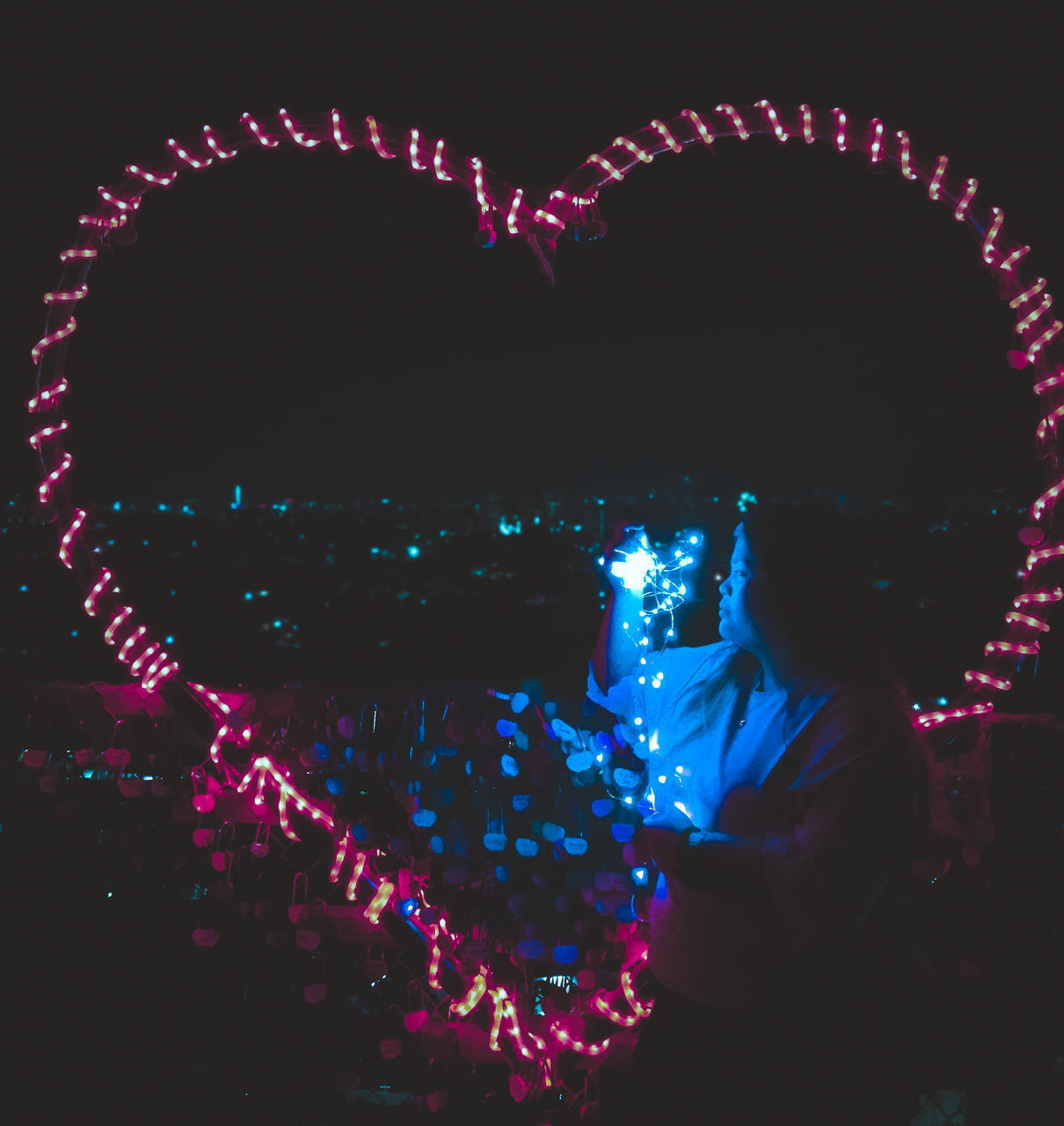 ILLUMINATED FIREWORKS OVER SILHOUETTE AT NIGHT