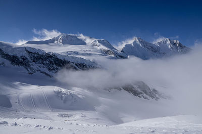 Scenic view of snow covered mountains against sky