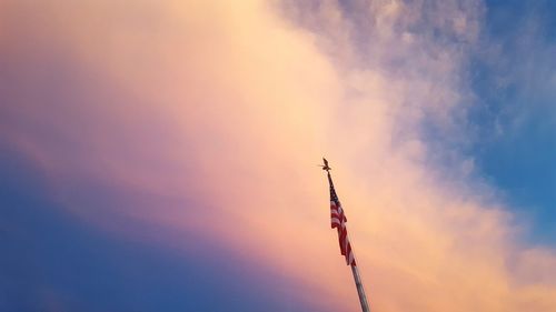 Low angle view of american flag against sky during sunset