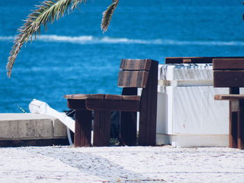 Close-up of chairs at beach against sky