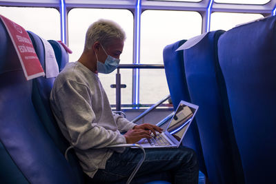 Side view of man using laptop