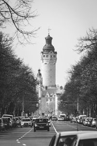 Cars on road in city against sky