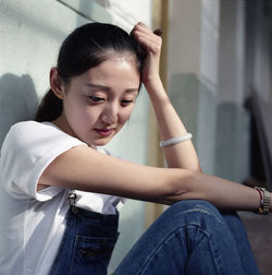 Depressed woman sitting against wall