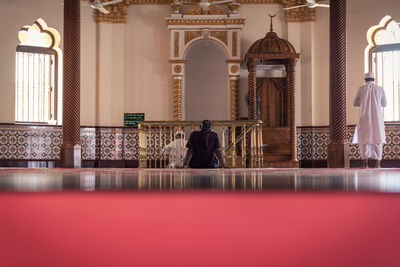 Rear view of people praying in mosque