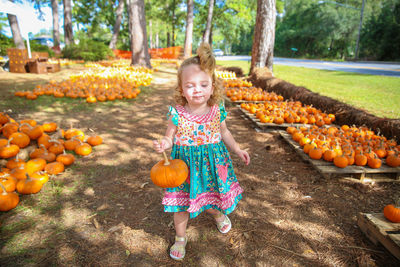 Full length portrait of smiling girl standing in park