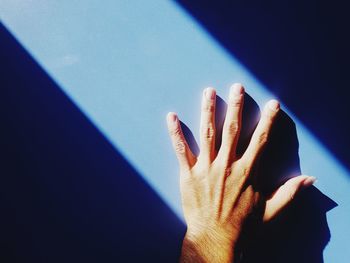Cropped hand on wall