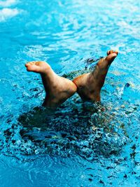 Low section of person swimming in pool