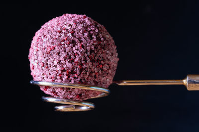 Close-up of pink cake against black background