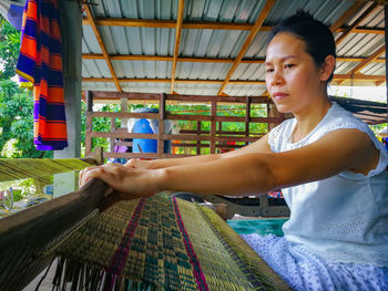 Woman weaving carpet at workshop