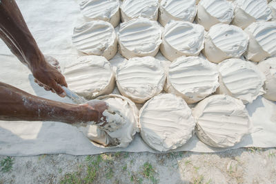 Cropped hands of man filling dough in bowls