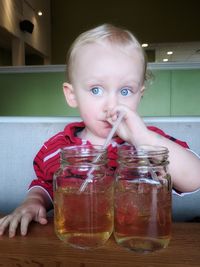 Close-up of cute boy with drinks on table