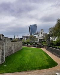 Buildings in city against cloudy sky
