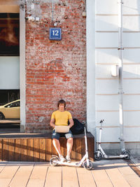 Man sits with laptop in street cafe. freelancer at work. student learns remotely open air workplace.