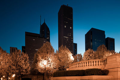 Low angle view of illuminated buildings against clear sky at night