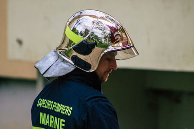 Portrait of man wearing mask standing against wall