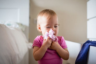 Mischievous baby plays with clothes in drawers, tidies up the bedroom with closed eyes