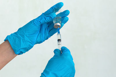 Cropped hands of doctor holding syringe with vial at hospital