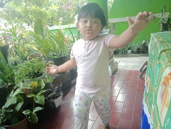 Full length of girl standing by plants