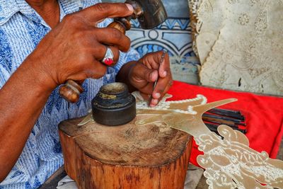 Midsection of man making craft product in workshop