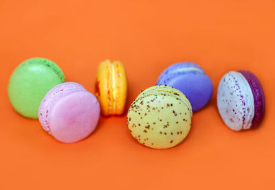 Close-up of multi colored candies against orange background