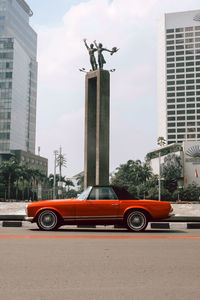 Vintage car on road against buildings