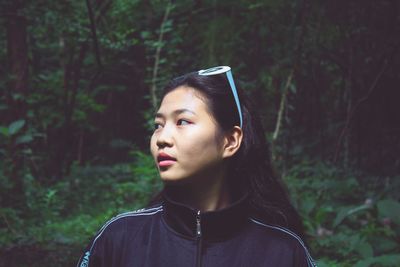 Portrait of young woman looking away in forest