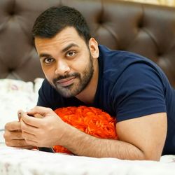 Portrait of man sitting on bed at home