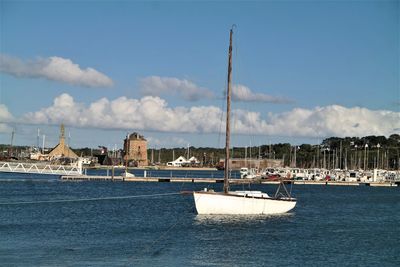 Sailboats in sea against sky in city