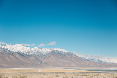 Scenic view of mountains against blue sky