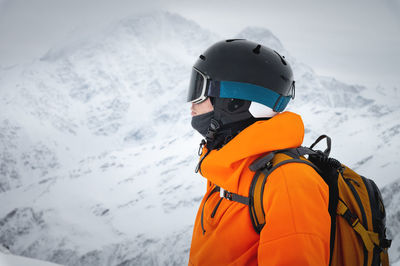 Portrait of a young adult in a ski helmet and goggles, with high