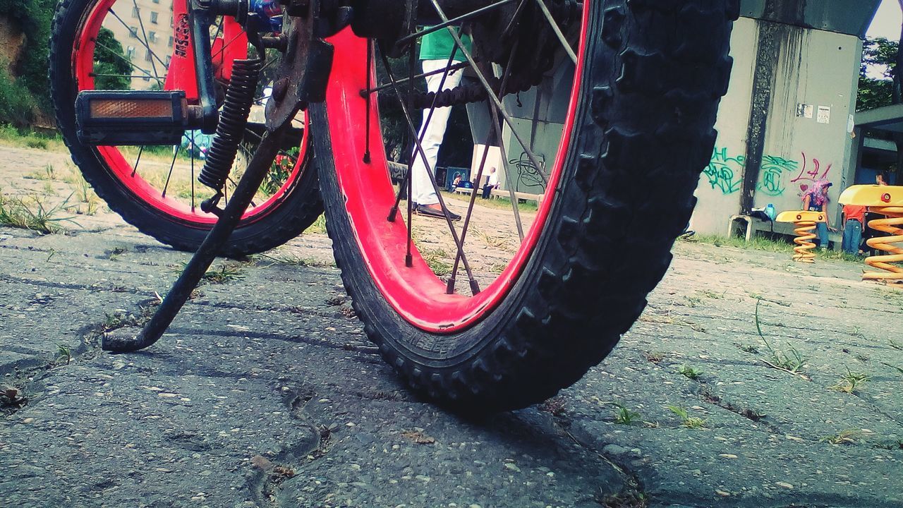 CLOSE-UP OF BICYCLE PARKED BY TIRE