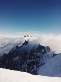 Scenic view of snow mountains against blue sky