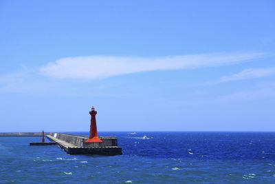 Lighthouse on sea against sky