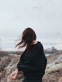 Woman standing at beach against sky