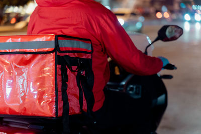 Rear view of man standing by car