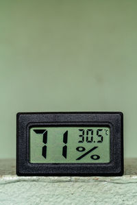 Digital thermometer and hygrometer on the green background