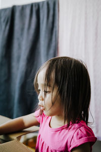 Close-up of girl with cardboard box at home
