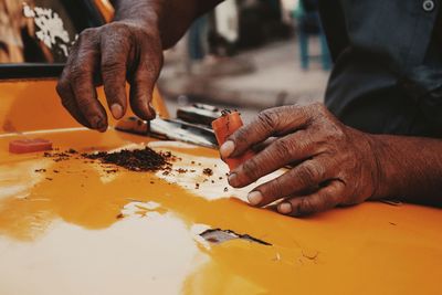 Midsection of man with tobacco holding container