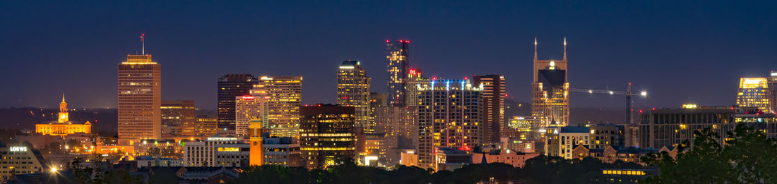 Panoramic view of illuminated buildings against sky at night