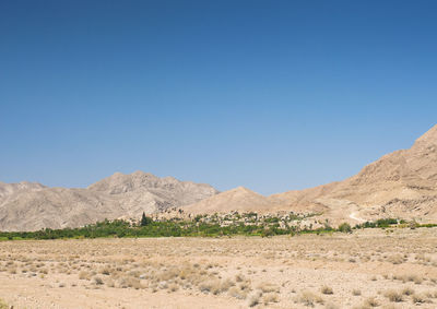 Scenic view of desert against clear blue sky